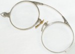 14k White Gold Spectacles Folding A set of glasses with a loop for attaching to a châtelaine. The frames are engraved 14k white gold and measure 4 inches across, with magnification lenses. Circa 1900.