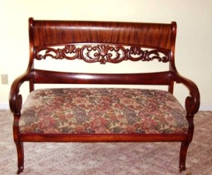 ribbon-striped The ribbon-stripe pattern in the crest rail of this early 20th century loveseat is made with African Khaya mahogany that has a pronounced pattern.
