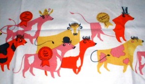 tkbeefcloth09 Although harder to find, Keefe did a number of tablecloth designs. This one has Cattle on Parade, with the different beef cows sporting different hats and signs for cuts of beef.
