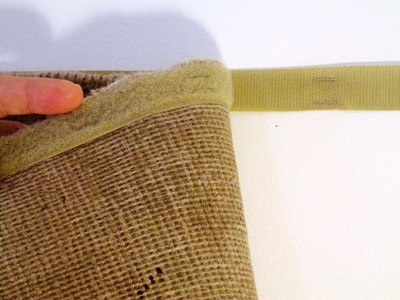 velcro-strip To display a rug on a wall, staple one strip of Velcro to your wall at a desired place making sure the sticky stuff shows. You may also put in a few nails, evenly spaced if the rug is on the heavy side. Then staple the other half of the tape to the back of the rug along the top edge making sure the tape is not showing. Don't worry, the staples will not hurt the rug and the rug pile will hide them from view in the front.