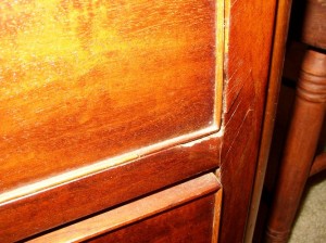 early-warning The channel gouged in the lower rail below this drawer and the loose veneer on the side are early warning signs that this drawer has problems. Fix it.