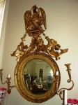 regency-mirror Anglo-American giltwood convex looking glass mirror in the Regency style, circa 1800-1825 ($9,900).