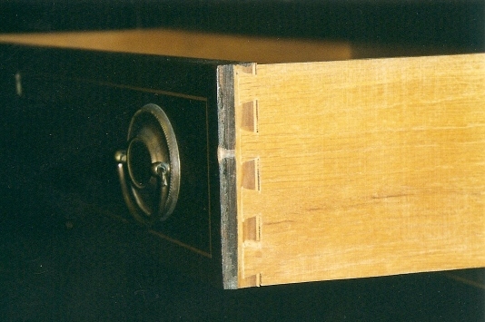 drawer-front The tag says “Solid mahogany chest…” Open up the first drawer and take a look at the joinery. The fact that the drawer is veneered is indicated by the light colored line at the rear of the dovetail. That is the fifth layer of veneer in the lumber plywood drawer front.