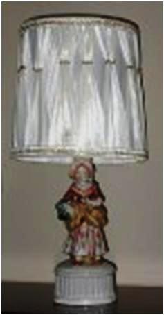 oj-fig-11 A glazed porcelain table lamp showing a well-dressed girl, 9 inches tall. The shade is in the 1950s style, but is probably not original to the lamp.
