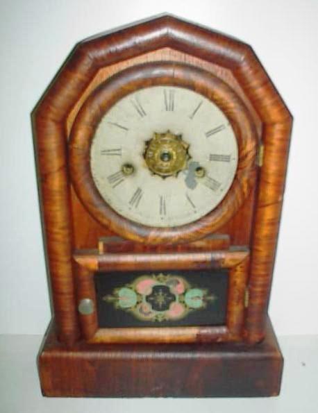 newhavenclcok This pine and Rosewood-veneer clock with a painted glass door is a typical New Haven Clock Company cottage clock.