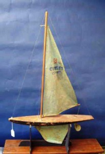 blogpondmodel7 This is a manufactured pond boat made by Curtiss, called the Curtiss Cutter. It is cutter rigged and has an original plastic sail and metal keel and rudder. It is 19 inches long and 29 ½ inches tall, with a solid body construction and a flat deck. It was made mid-20th century. Value in a retail setting is about $100.