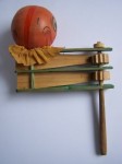 ratchet A German wood ratchet from 1920 with a composition pumpkin head and crepe paper collar. The ratchet makes a loud scraping noise when twirled.