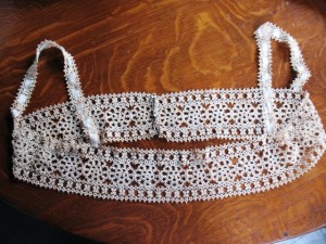tatting3 An early tatted edging for the top of a ladies undergarment or bodice. Since tatting is a loose stitch typically of cotton, which tended to stretch easily, the ribbon laced through the shoulder straps would have helped the straps keep their shape.