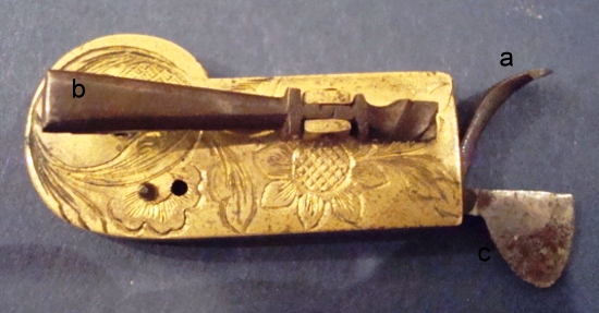 copy of bloglancet3 The parts of a spring-loaded lancet include the cocking mechanism (a), the trigger (b), and the blade (c), as seen on this highly engraved spring-loaded lancet by Kolb from Furth, Germany