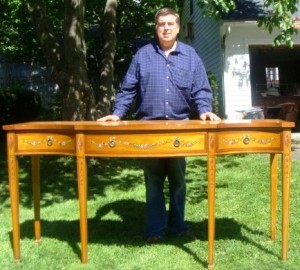 Tim with sideboard Auctioneer Tim Chapulis with an Edwardian Adams-style satinwood sideboard, ca. 1890-1910.