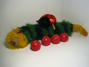 pilla Steiff’s 43-centimeter woven, plush caterpillar on eccentric wheels from 1980-83, accompanied by a modern, 10-cm “Cappy” red-and-black, plush ladybug.