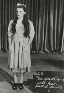 Judy Garland modeling the “test” dress and pinafore from “The Wizard of Oz” during a costume showing.