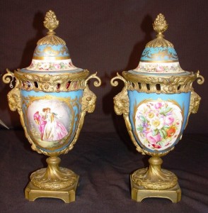 Available for purchase will be a pair of Sevres urns, capped with bronze mounting, ram's head and painted scene of French royalty, marked Sevres.