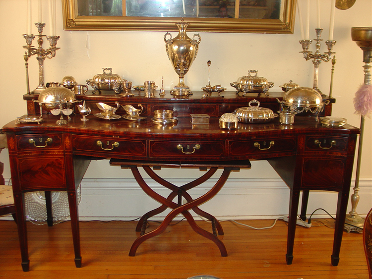 This Sheraton-style flame mahogany sideboard with great inlay supports sterling silver pieces.