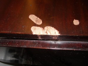 The damage to this table top occurred when the batteries of a portable television set corroded. Battery acid and furniture finish do not mix well.